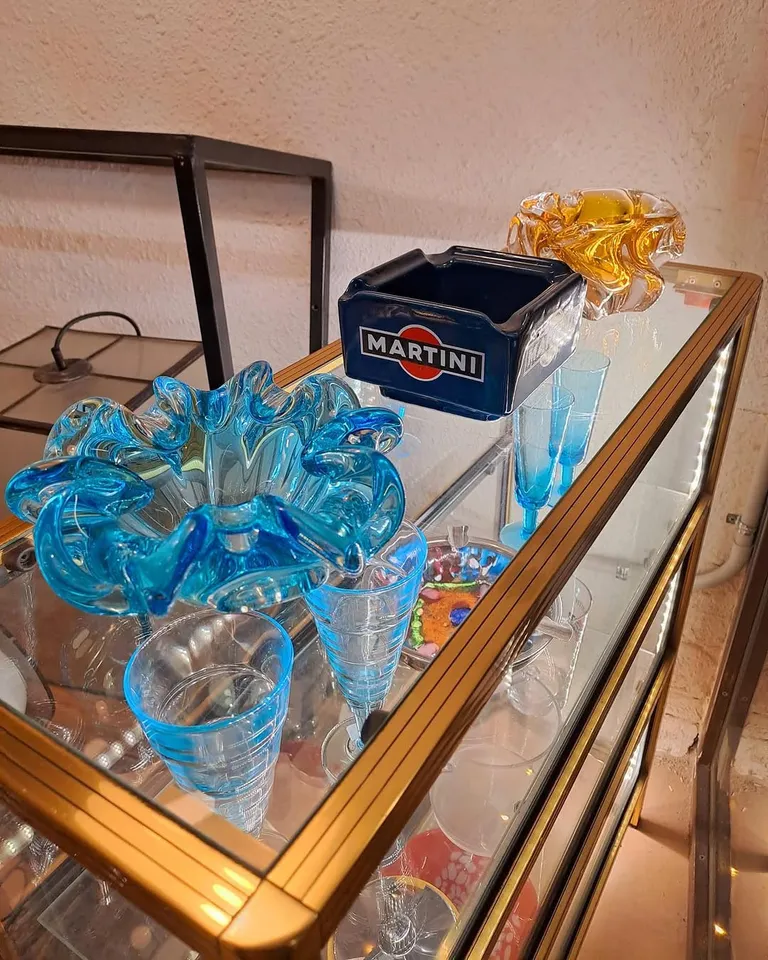 Carretó daurat amb peces de vidre blau i un cendrer Martini